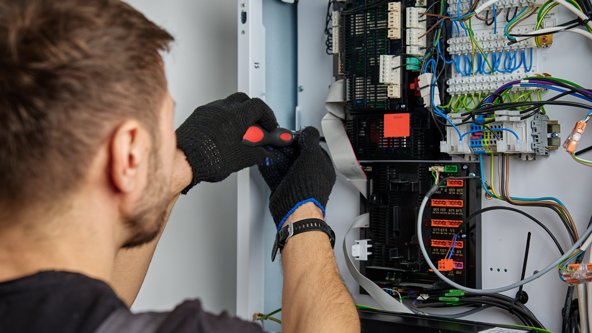 Qualified electrician carrying out work on an electrical control panel